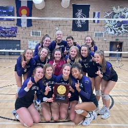 The DCCHS Girls Volleyball team on the volleyball court with their 2021 Regional Championship award.